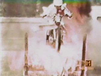 Motorcyclist jumping s cycle through fire
